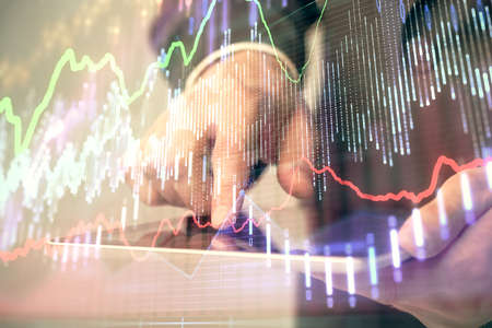 Multi exposure of man's hands holding and using a phone and financial chart drawing. Market analysis...