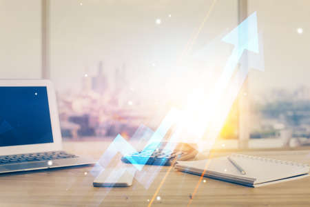 Computer on desktop with point up arrows hologram. Double exposure. Concept of success.の写真素材