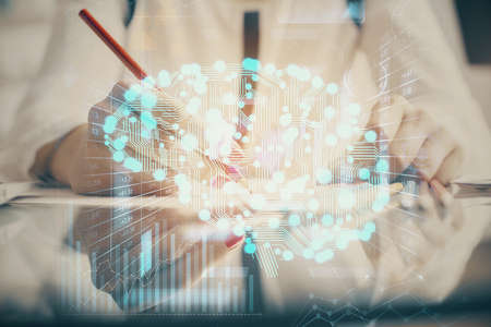 Multi exposure of woman's writing hand on background with brain hud. Concept of learning.