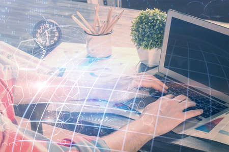 Double exposure of world map hologram with man working on computer on background. Concept of worldwideweb.の写真素材