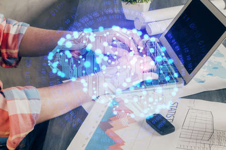 Businessman with computer background with brain theme hologram. Concept of brainstorm. Multi...