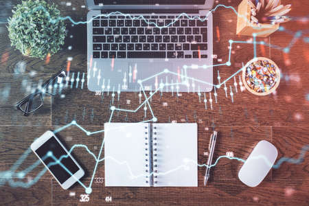 Stock market graph and top view computer on the table background. Double exposure. Concept of financial education.の写真素材