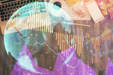 Financial market graph and top view computer on the desktop background. Double exposure. Investment...