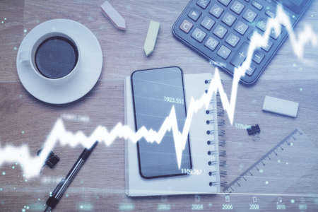 Multi exposure of forex graph hologram over desktop with phone. Top view. Mobile trade platform concept.の写真素材