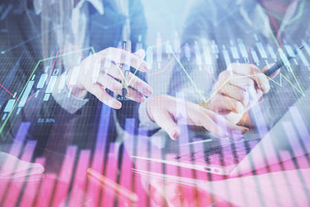 Multi exposure of man and woman working together and financial chart hologram. Business concept....