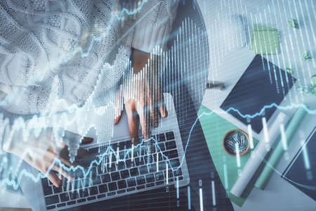 Multi exposure of woman hands working on computer and forex chart hologram drawing. Top View....