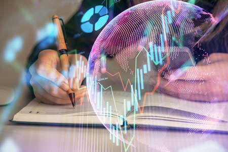 Double exposure of businesswoman hands typing on computer and forex graph hologram drawing. Financial analysis concept.の写真素材