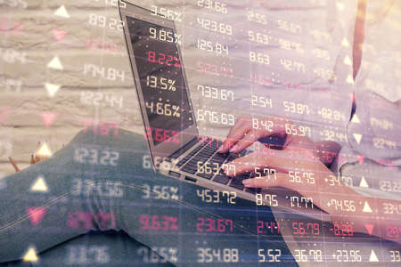 Double exposure of woman hands typing on computer and forex chart hologram drawing. Stock market analysis concept.の写真素材
