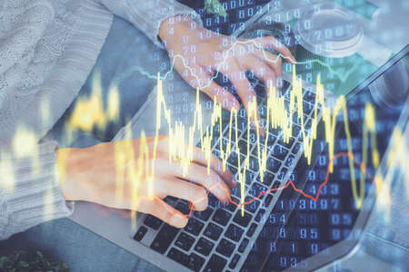 Double exposure of woman hands typing on computer and forex chart hologram drawing. Stock market...