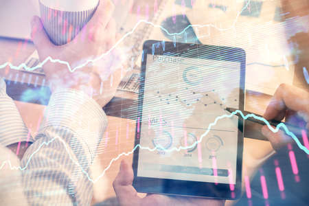 Double exposure of man's hands holding and using a phone and financial chart drawing. Market analysis concept.の写真素材