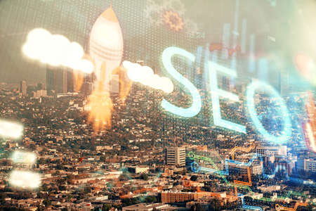 SEO hologram on city view with skyscrapers background double exposure. Search optimization concept.の写真素材