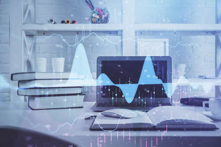 Forex market chart hologram and personal computer background. Double exposure. Concept of...