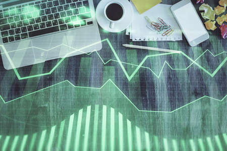 Financial market graph and top view computer on the desktop background. Double exposure. Investment...