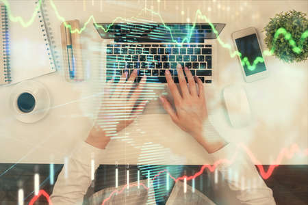 Double exposure of woman hands working on computer and forex chart hologram drawing. Top View....