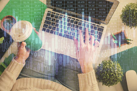 Double exposure of woman hands working on computer and forex chart hologram drawing. Top View....