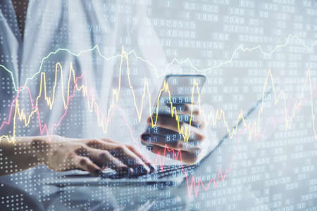 Double exposure of financial graph sketch hologram and woman holding and using a mobile device....