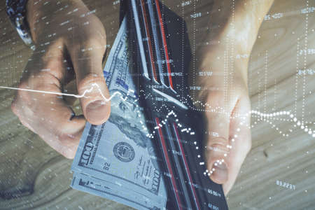 Multi exposure of forex graph drawing hologram and USA dollars bills and man hands. Technical...