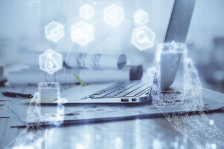 Computer on desktop in office with technology theme hologram. Double exposure. Tech concept.