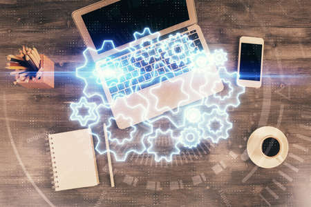 Business theme hologram drawings over computer on the desktop background. Top view. Multi exposure....