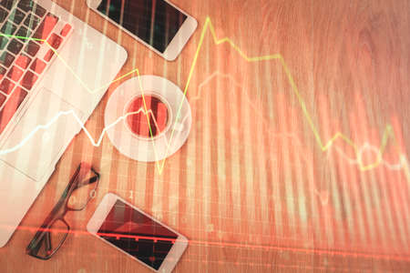 Double exposure of forex chart hologram over desktop with phone. Top view. Mobile trade platform concept.の写真素材
