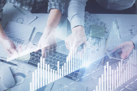 Double exposure of man and woman working together and forex graph hologram drawing. Financial...