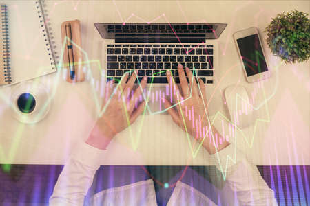 Double exposure of woman hands working on computer and forex chart hologram drawing. Top View....