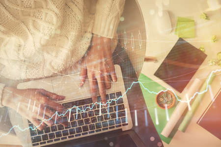 Multi exposure of woman hands working on computer and forex chart hologram drawing. Top View....