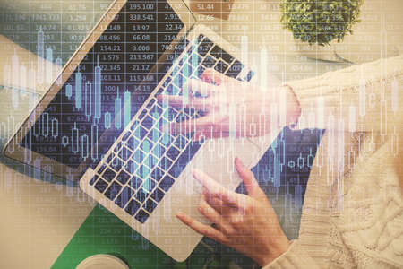 Double exposure of woman hands working on computer and forex chart hologram drawing. Top View....