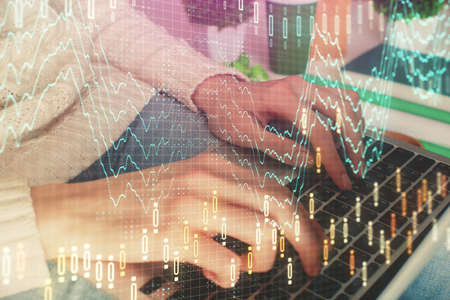 Double exposure of woman hands typing on computer and forex chart hologram drawing. Stock market...