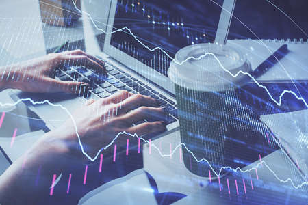 Double exposure of woman hands typing on computer and forex chart hologram drawing. Stock market...