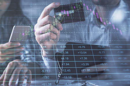 Double exposure of man and woman on-line shopping holding a credit card and forex graph hologram...