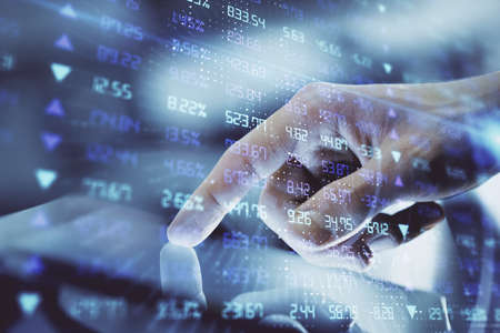 Multi exposure of man's hands holding and using a digital phone and forex graph drawing. Financial...