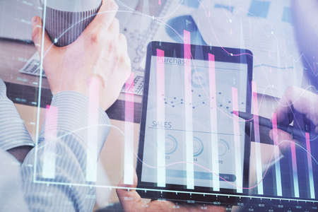 Double exposure of man's hands holding and using a phone and financial chart drawing. Market...