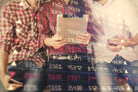 Double exposure of forex graph drawing and man and woman working together holding and using a mobile device. Trade concept.の写真素材