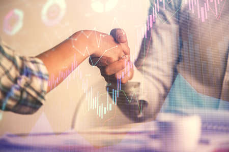 Double exposure of forex graph hologram and handshake of two men. Stock market concept.の写真素材
