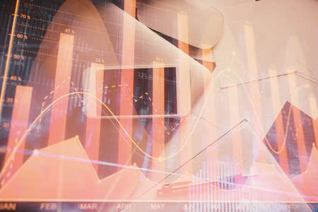 Multi exposure of forex graph hologram over desktop with phone. Top view. Mobile trade platform...