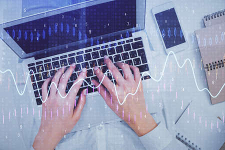 Double exposure of woman hands working on computer and forex chart hologram drawing. Top View....