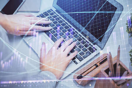 Double exposure of woman hands typing on computer and forex chart hologram drawing. Stock market...