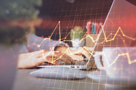 Double exposure of woman hands typing on computer and forex chart hologram drawing. Stock market invest concept.の写真素材