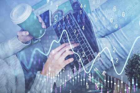 Double exposure of woman hands typing on computer and forex chart hologram drawing. Stock market...