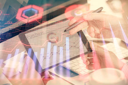 Double exposure of man's hands holding and using a phone and financial chart drawing. Market...