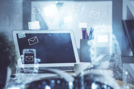 Desktop computer background in office and flying envelops hologram drawing. Double exposure. Electronic mail concept.の写真素材