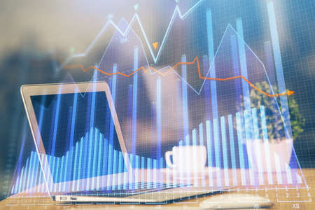 Financial graph colorful drawing and table with computer on background. Double exposure. Concept of international markets.の写真素材