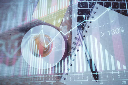 Double exposure of forex chart drawing over table background with computer. Concept of financial...