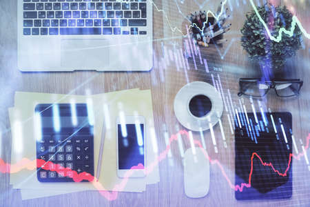 Double exposure of forex chart hologram over desktop with phone. Top view. Mobile trade platform concept.の写真素材