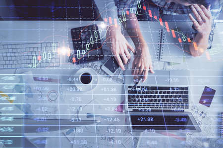 Double exposure of man and woman working together and financial graph hologram drawing. market...