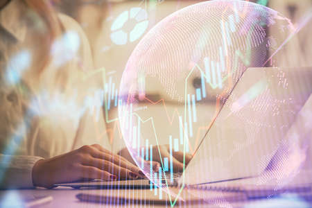 Double exposure of woman hands working on computer and forex graph hologram drawing. Financial analysis concept.の写真素材