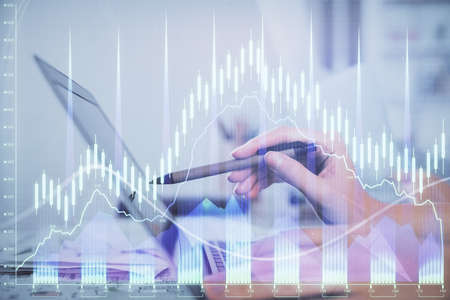 Multi exposure of woman hands typing on computer and financial graph hologram drawing. Stock market...