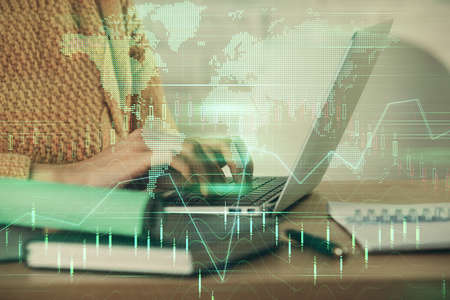 Double exposure of woman hands typing on computer and forex chart hologram drawing. Stock market...