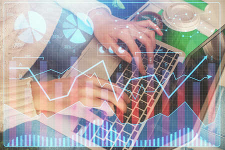 Double exposure of woman hands typing on computer and forex chart hologram drawing. Stock market...